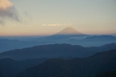 夕日に淡いオレンジ色の富士山