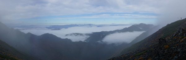 ガスの薄くなった間ノ岳登山道にて、遠くに中央アルプス、右仙丈ヶ岳の傍に槍穂連峰